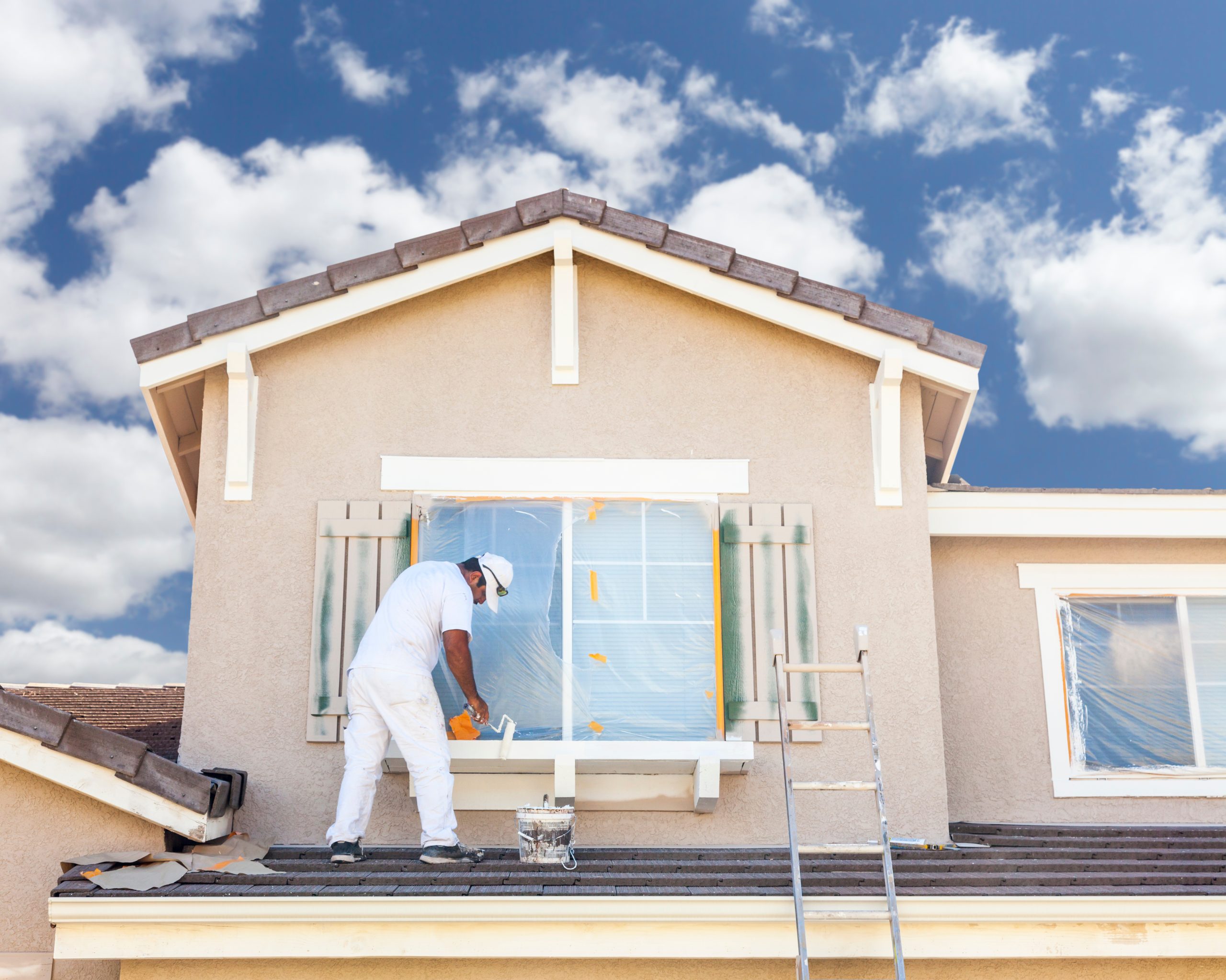 Busy House Painter Painting the Trim And Shutters of A Home.